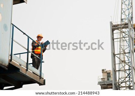 Manager controlling cargo embarkation from the height