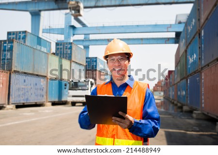 Cheerful dock worker controlling working process in the seaport