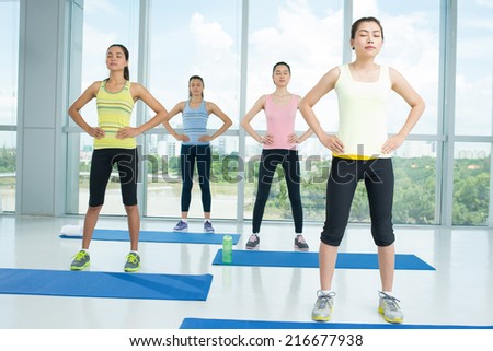 Group of young ladies doing relaxation exercise in the fitness club