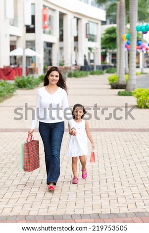 Indian mother walking with her daughter along the street