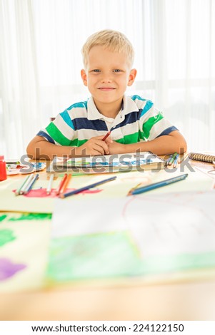 Portrait of smiling boy drawing with pencils