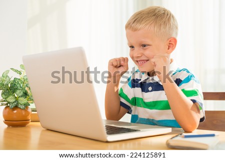 Excited little boy looking at the laptop screen