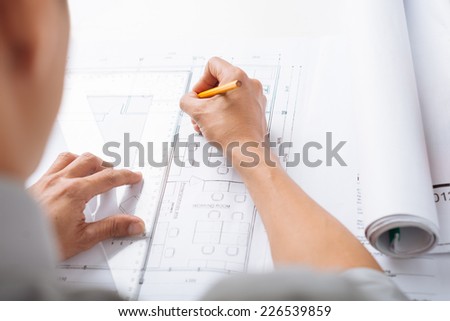 Engineer sketching construction project, view over his shoulder