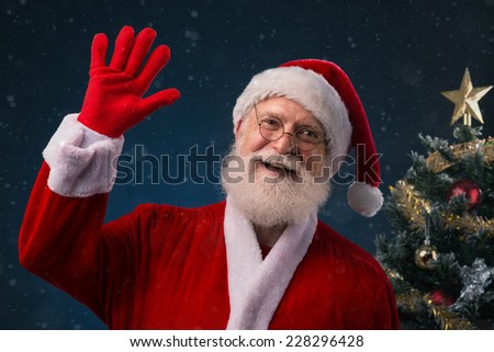 Smiling Santa Claus saying hello and waving with his hand