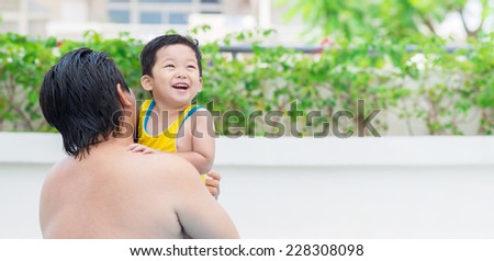 Man and his little cheerful son in the swimming pool