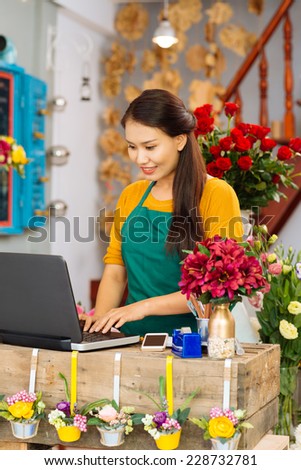 Woman working at cash desk in flower shop