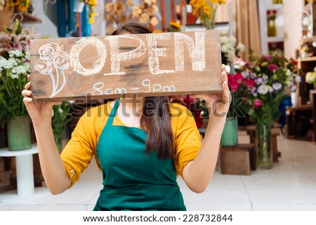 Owner of the shop posing with tablet sign