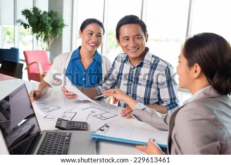 Middle-aged couple meeting financial adviser for real estate project