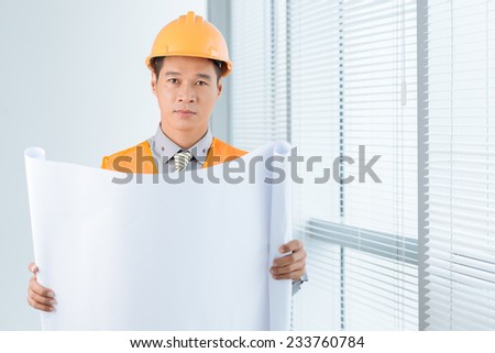 Portrait of civil engineer in a hardhat holding empty document