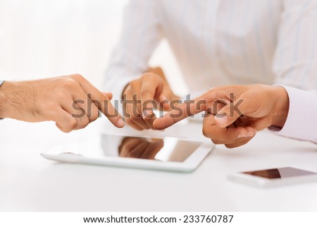 Hands of business people pointing at the digital tablet during the meeting