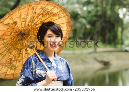 Pretty Japanese girl in jukata holding parasol