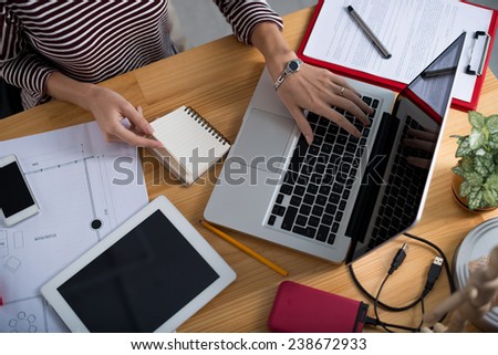 Hands of female architect working on laptop, view from above