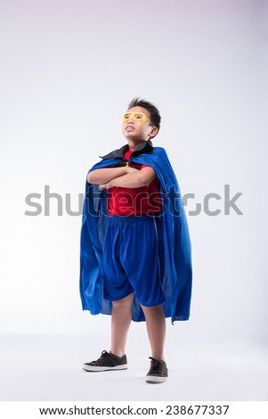 Confident boy pretending to be a superhero looking up