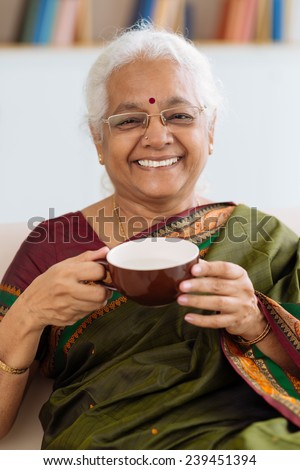 Portrait of senior Indian woman in sari drinking tea
