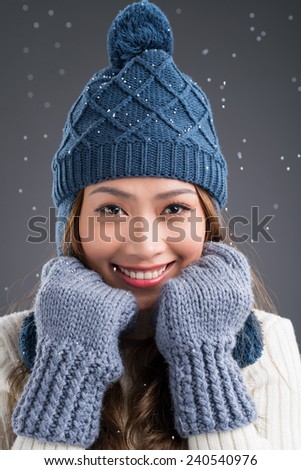 Portrait of smiling Asian woman in knitted hat and gloves