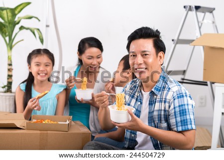 Happy Vietnamese family having first meal in their new house