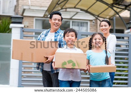 Happy Vietnamese family with cardboard boxes