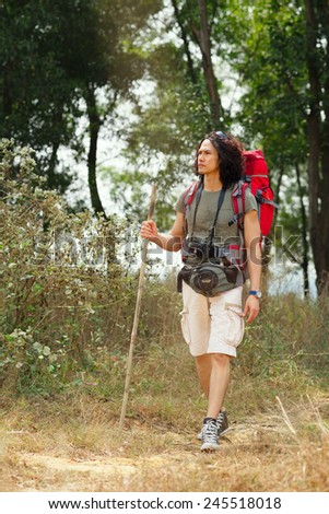 Mixed-race adventurer hiking with a stick