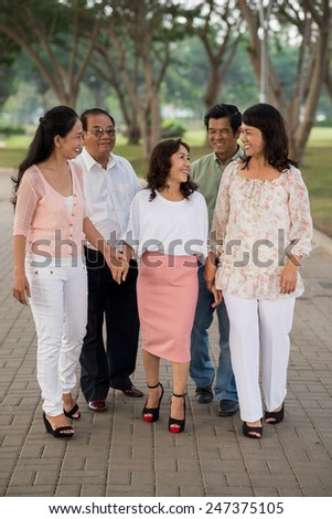 Group of aged Vietnamese people walking in the park