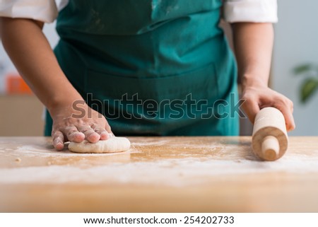 Cook rolling out a dough ball