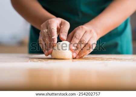 Hands forming dough balls