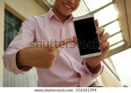 Smiling man pointing at the screen of the smartphone