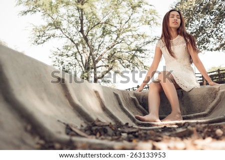 Peaceful Asian woman sitting in boat with her eyes closed