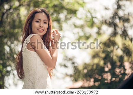 Portrait of smiling attractive Vietnamese girl in the park
