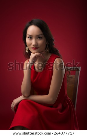 Portrait of gorgeous Chinese woman sitting on a chair