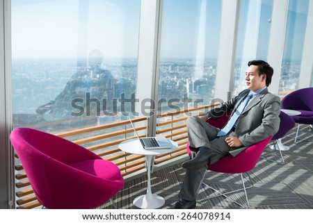 Pensive businessman looking at the city through the office window