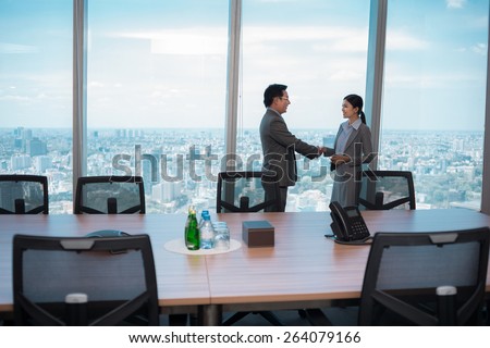 Vietnamese businessman greeting his female colleague before conference