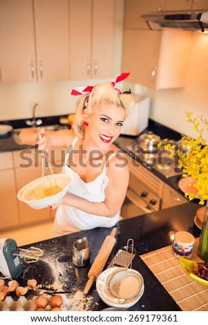 Gorgeous pin-up housewife cooking in the kitchen