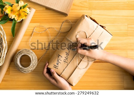 Female hands signing package with birthday present