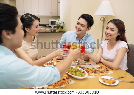Four young people talking and drinking cocktails at the dinner