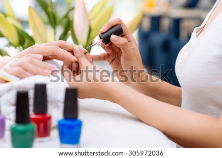 Hands of woman getting manicure in beauty salon