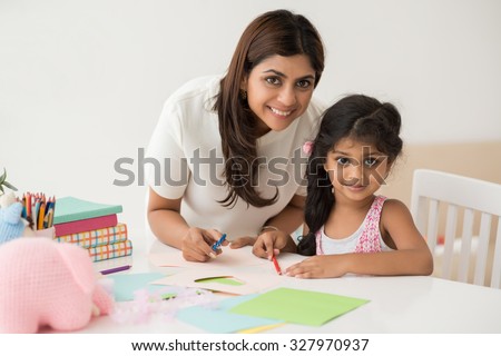 : Little girl making greeting card with her mother