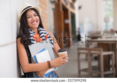 Portrait of Asian female student with textbooks and coffee