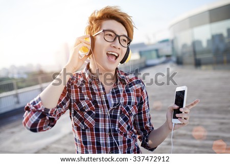Joyful guy dancing to the music in his headphones