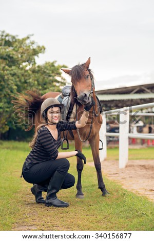 Portrait of young equestrian and her pony at the horse club