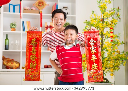 Asian father and son holding banners with wishes for the New Year