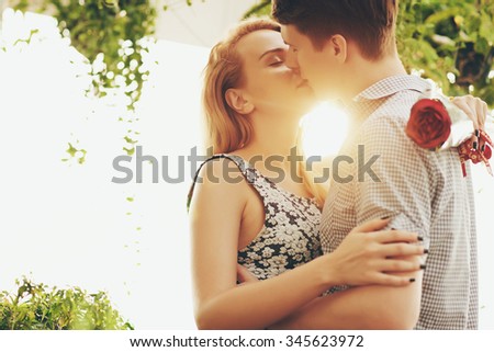 Young couple hugging and kissing at sunset