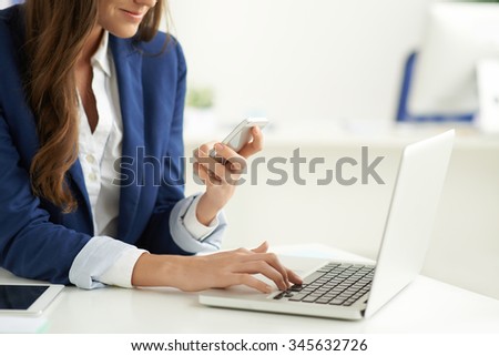 Business lady texting and using laptop in the same time