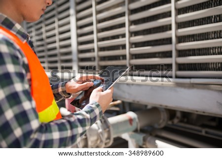 Cropped image of factory worker using application on digital tablet