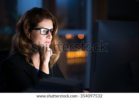 Concentrated business lady reading information on glowing screen on her computer