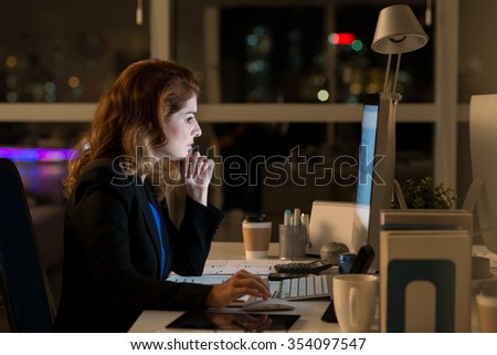 Business lady working on computer in dark office