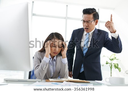 Angry Asian businessman shouting at his employee