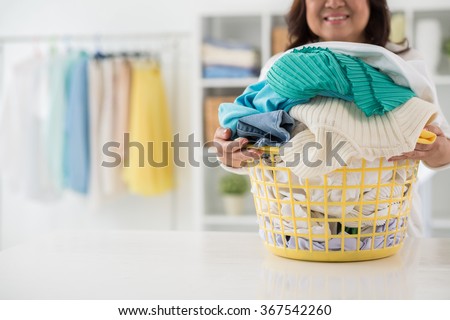 Housewife with big basket of freshly washed clothes