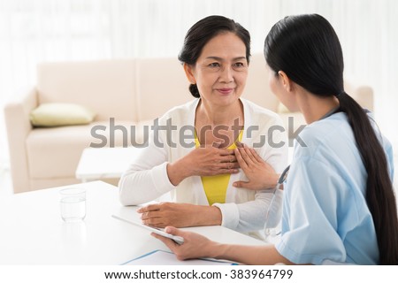 General practitioner and her aged patient talking about heart diseases