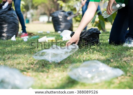 Volunteers picking up trash on a meadow