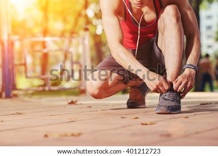 Jogger tying shoe laces before jogging